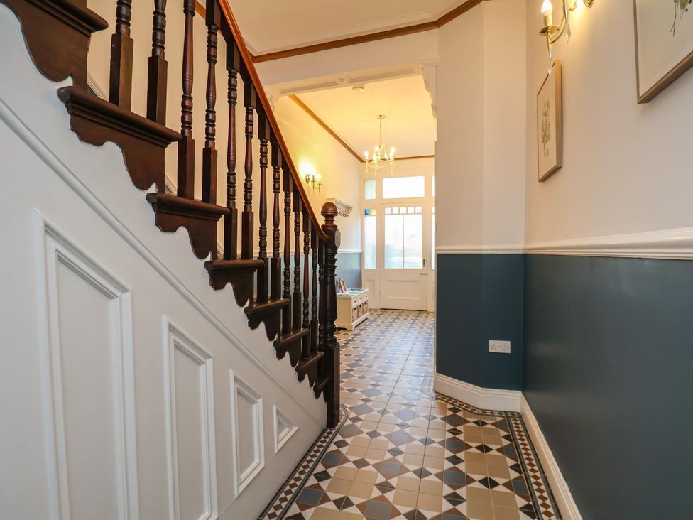 A hallway with a staircase and patterned tiles at Kingfisher House in Staithes