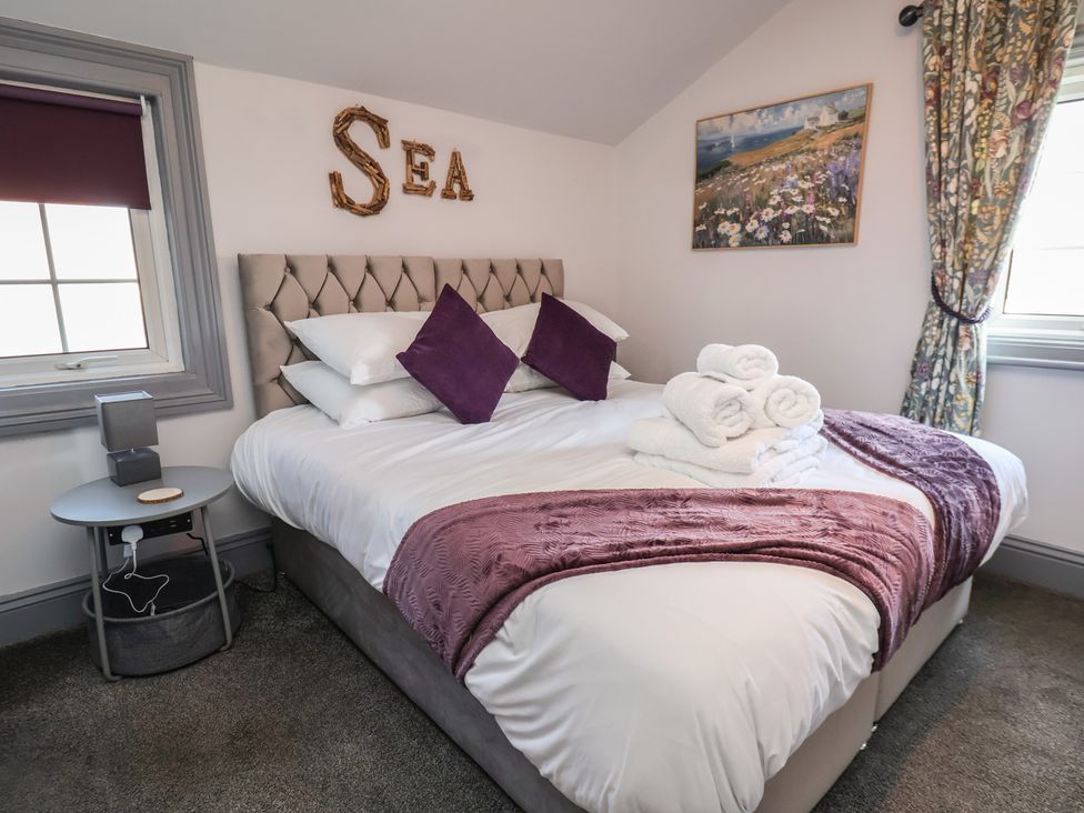 A bedroom with a bed and side table at Kingfisher House in Staithes