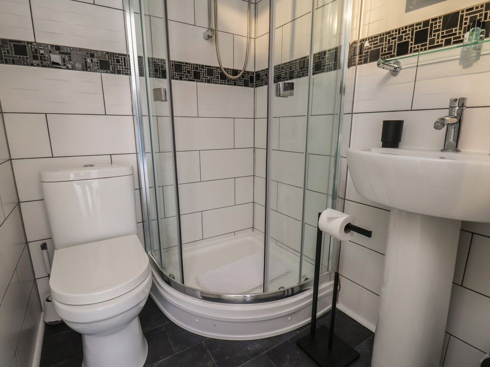 A bathroom with a shower, toilet, and sink at Kingfisher House in Staithes