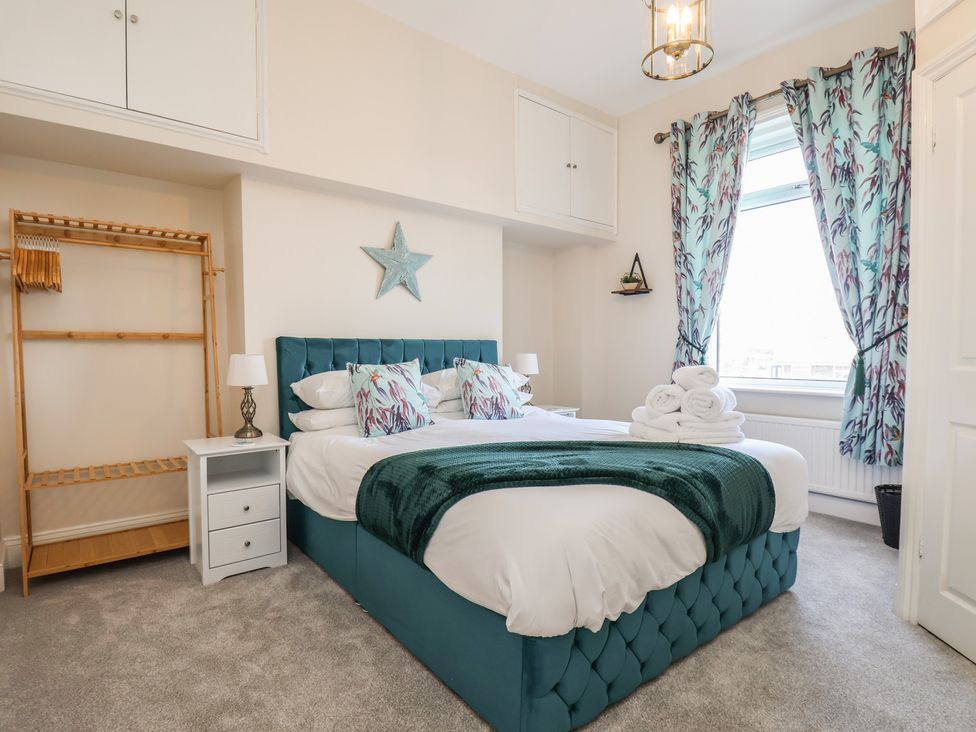 A bedroom with a bed and wardrobe at Kingfisher House in Staithes