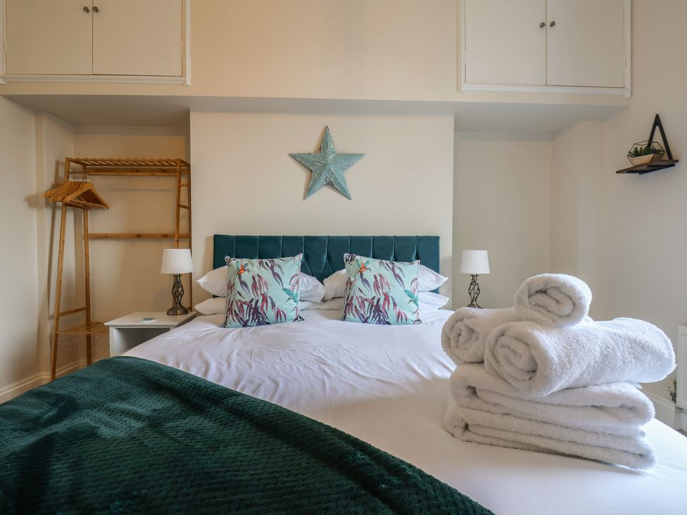 A bedroom with a bed and towels arranged at Kingfisher House in Staithes