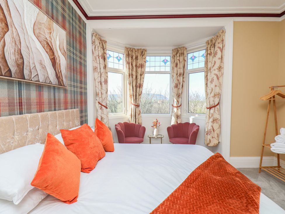 A bedroom with a bed and chairs at Kingfisher House in Staithes
