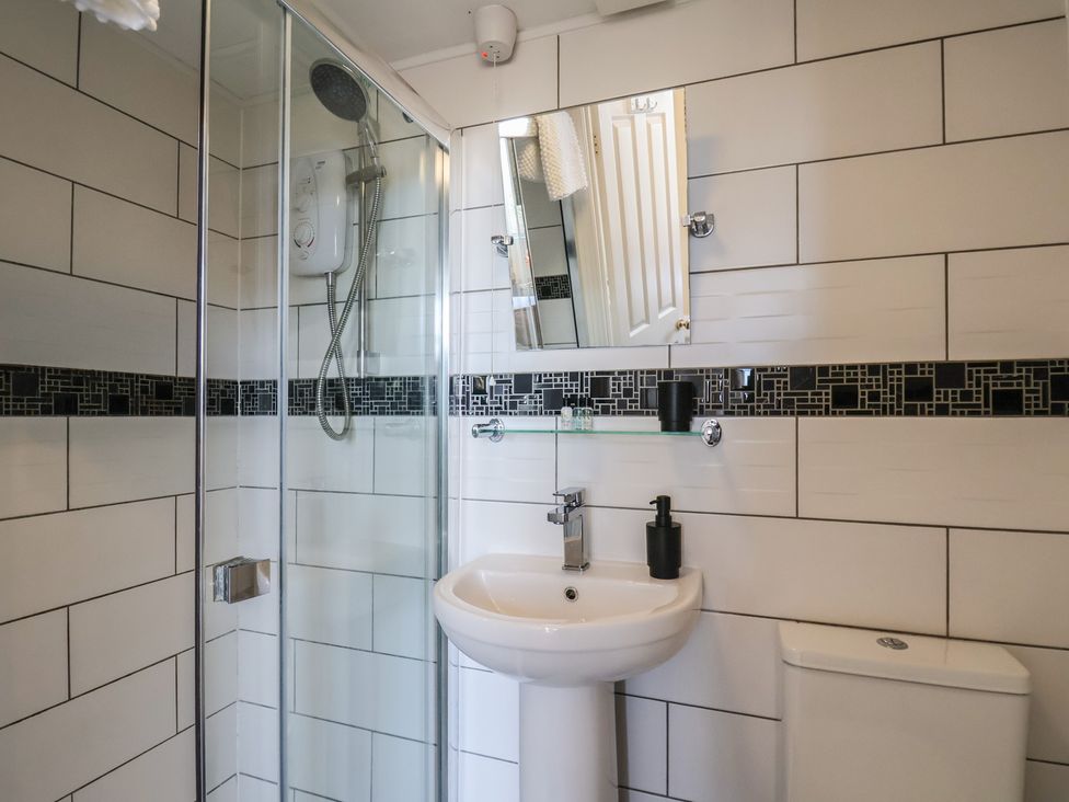 A bathroom with a shower, sink, and toilet at Kingfisher House, Staithes