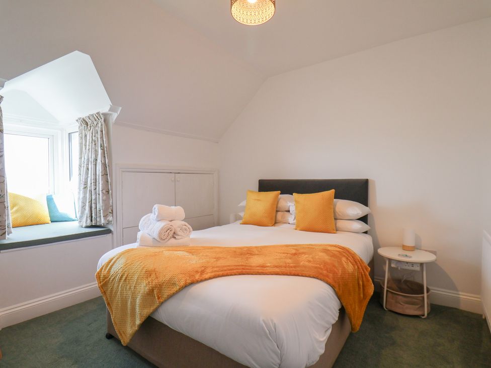 A bedroom with a bed and window seat at Kingfisher House in Staithes