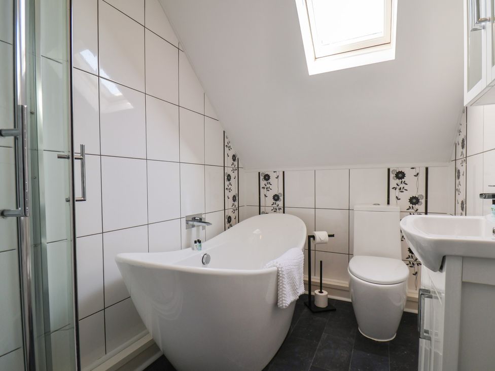 A bathroom with a bathtub, toilet, and sink at Kingfisher House in Staithes