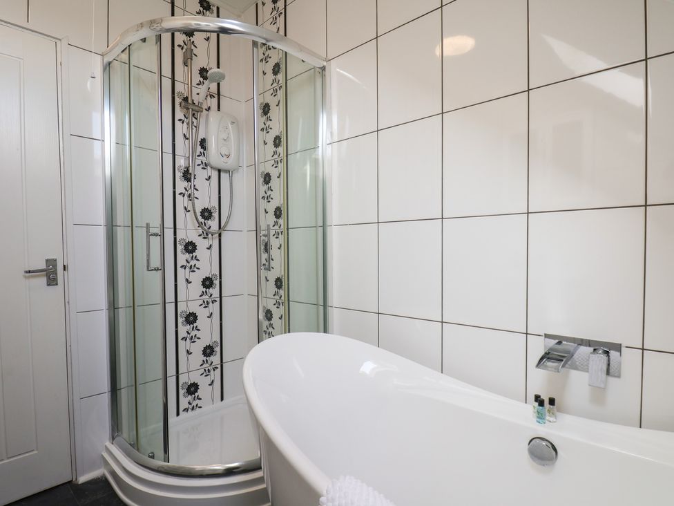 A bathroom with a shower and bathtub at Kingfisher House in Staithes