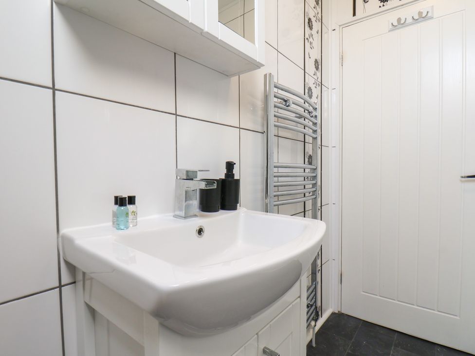 A bathroom with a sink and towel radiator at Kingfisher House in Staithes