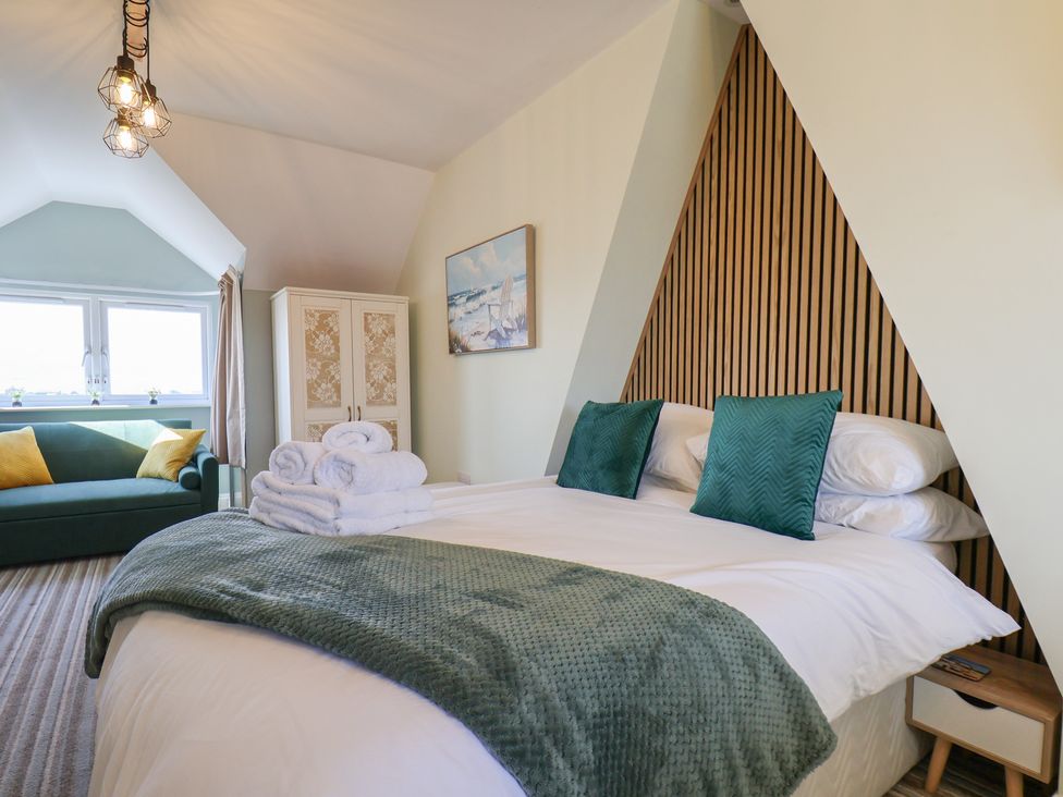 A bedroom with a bed and sofa at Kingfisher House in Staithes