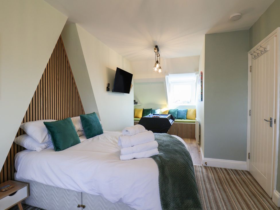 A bedroom with a bed and television at Kingfisher House in Staithes