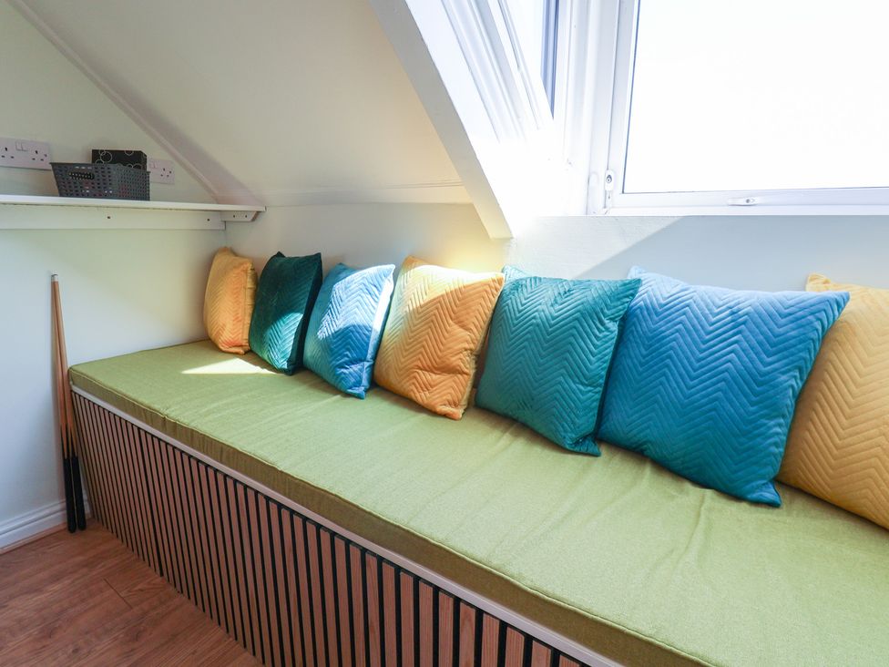 A snug area with cushions on a seating at Kingfisher House in Staithes