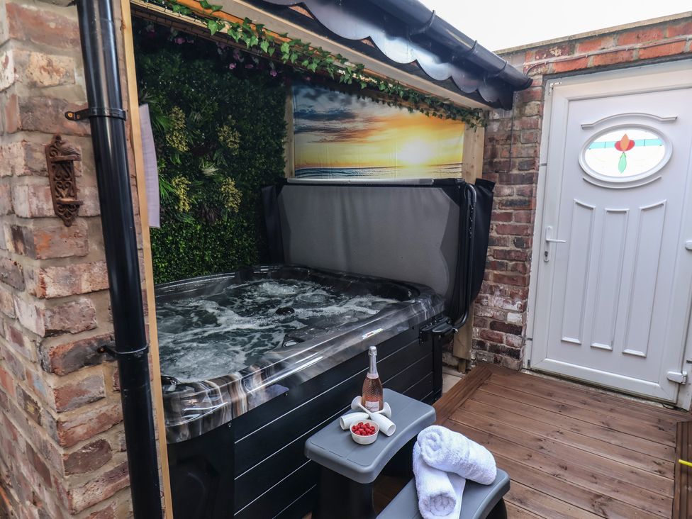 An outdoor area with a hot tub and a table at Kingfisher House in Staithes