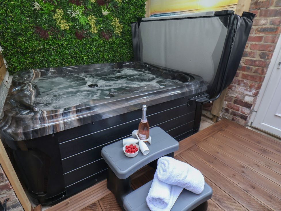 A hot tub with a bottle of champagne and strawberries at Kingfisher House in Staithes