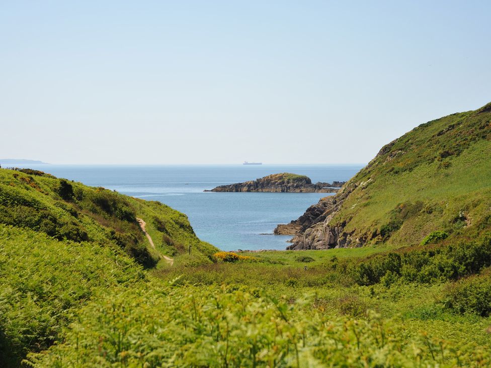 A coastal view with hills and a ship at 5 Cart-Tws Bach in St Davids