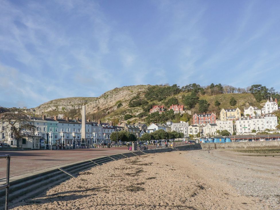 A beach with houses and hills in the background at The Hayloft in Llysfaen