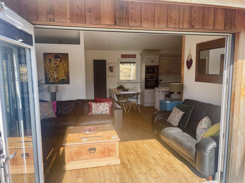 A living room with a coffee table and sofas at Woodburn Lodge in Otterburn