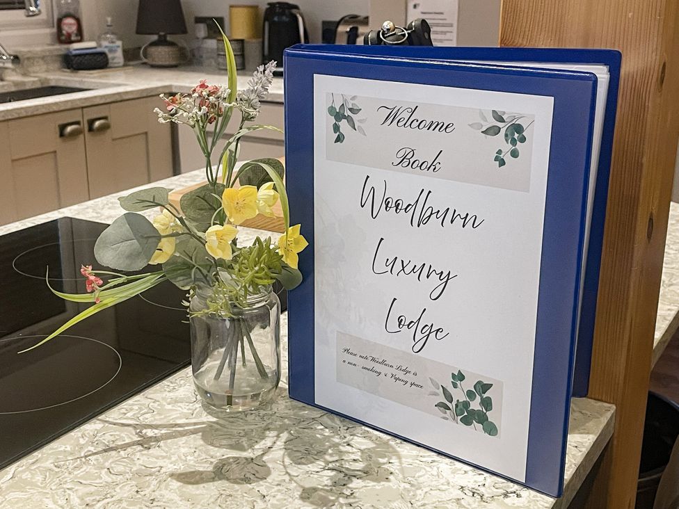 A welcome book on a kitchen countertop at Woodburn Lodge Otterburn