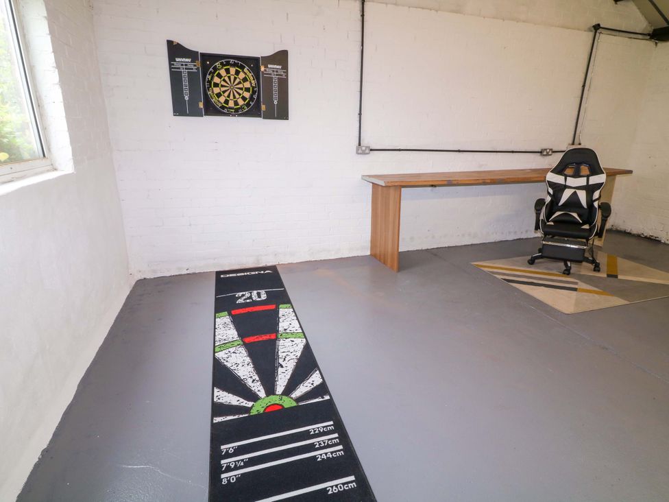 A game room with a dartboard and a table at Oxcroft View near Bolsover