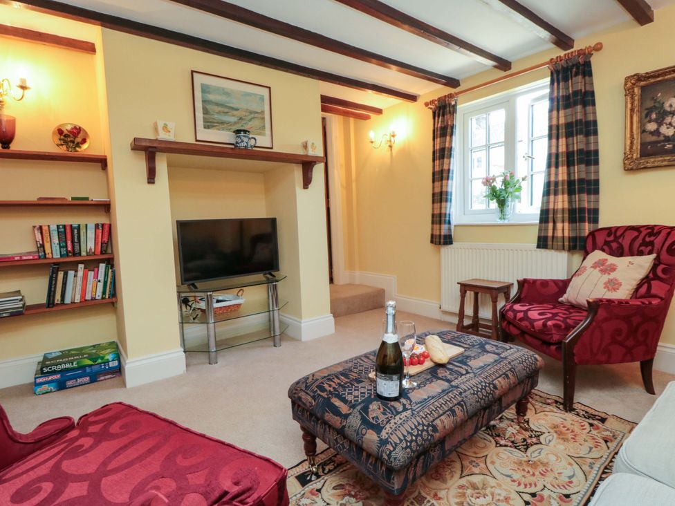 A living room with a television and bookshelves at Spring Cottage in York