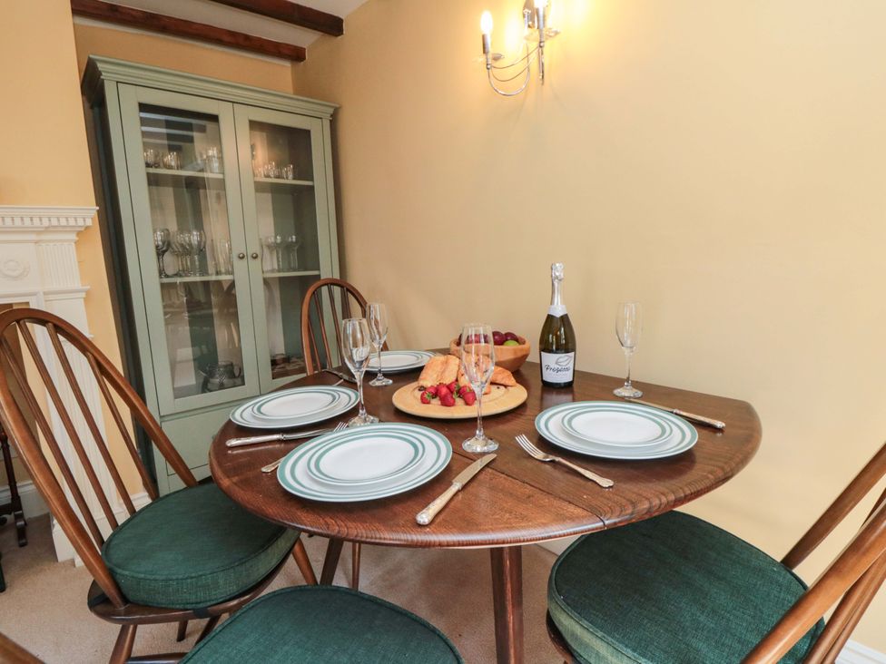A dining room with a round table set for four at Spring Cottage in York