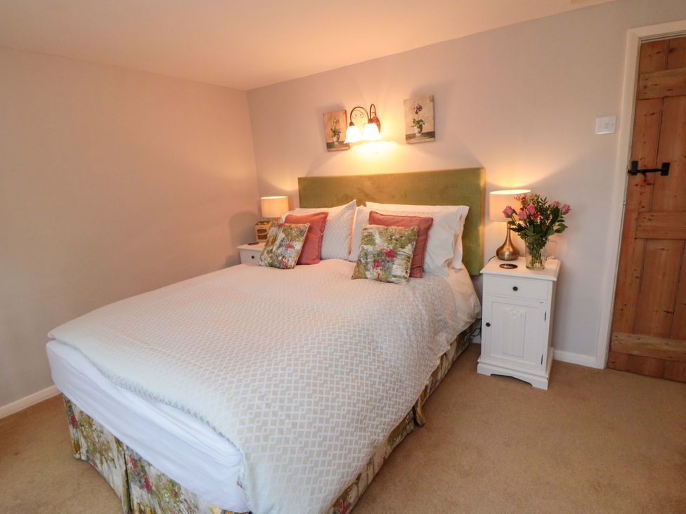 A bedroom with a bed and bedside table at Spring Cottage in York