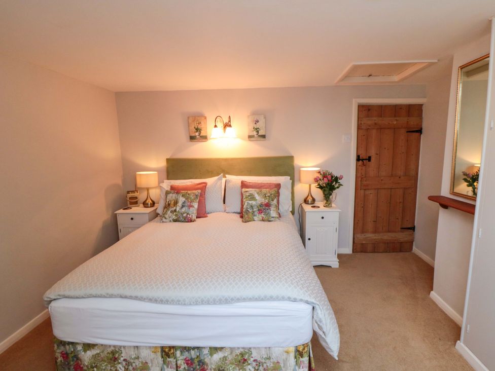 A bedroom with a bed and bedside tables at Spring Cottage York