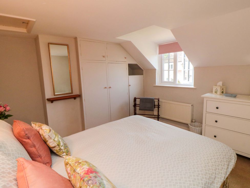 A bedroom with a bed and wardrobe at Spring Cottage in York