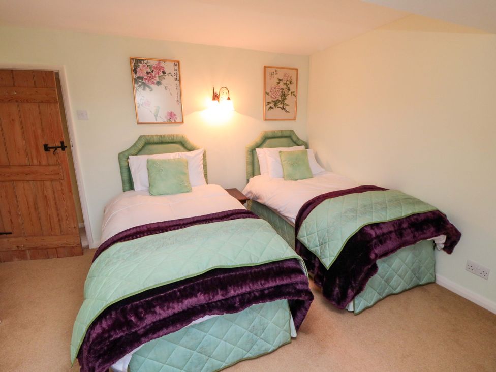 A bedroom with two beds and wall art at Spring Cottage in York