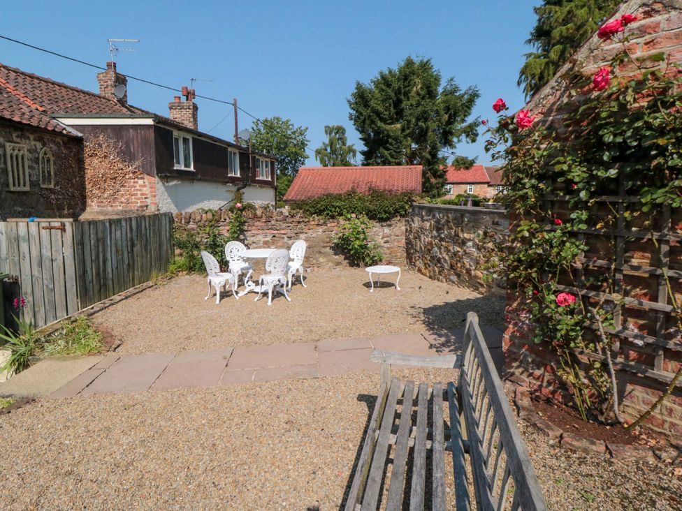 A garden with a table and chairs at Spring Cottage in York