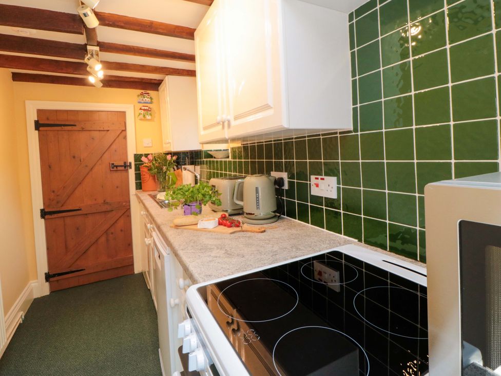 A kitchen with a kettle and plants at Spring Cottage in Husthwaite