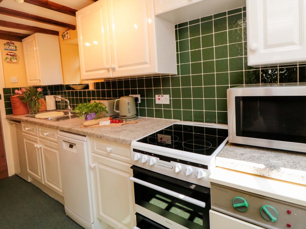 A kitchen with stove and microwave at Spring Cottage Husthwaite