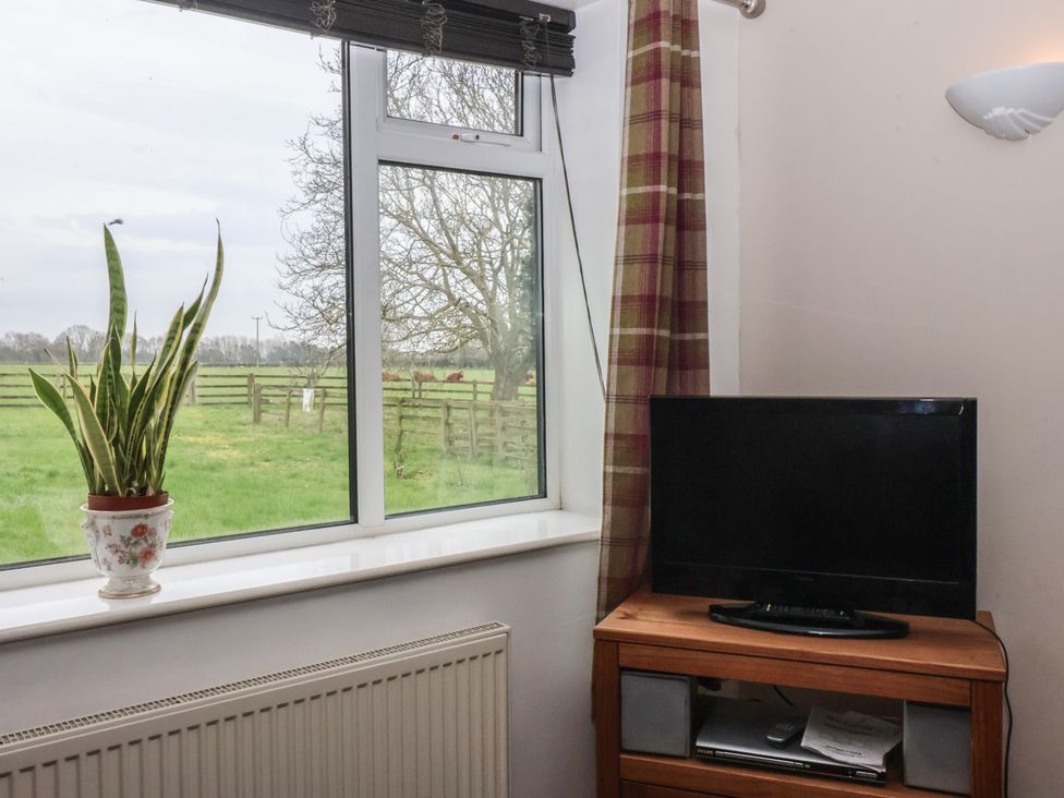 A living room with a window and television at Walnut Cottage in Helmsley