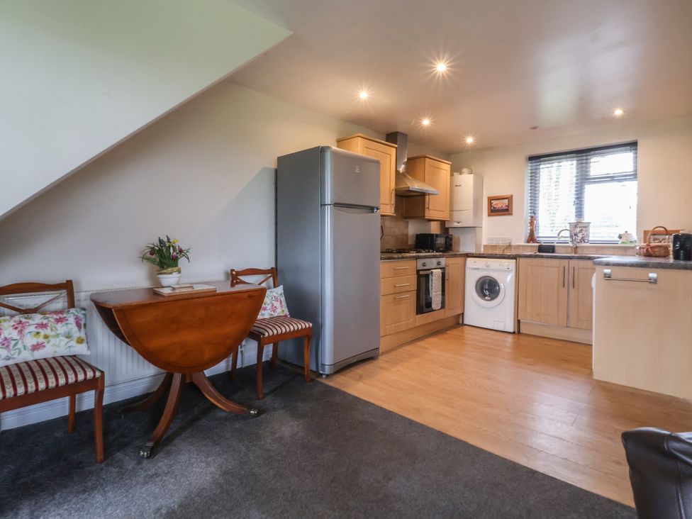 A kitchen with appliances and seating at Walnut Cottage in Helmsley