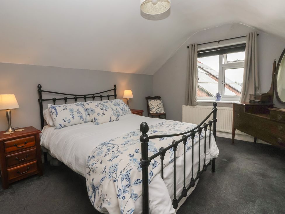 A bedroom with a bed and nightstand at Walnut Cottage in Helmsley