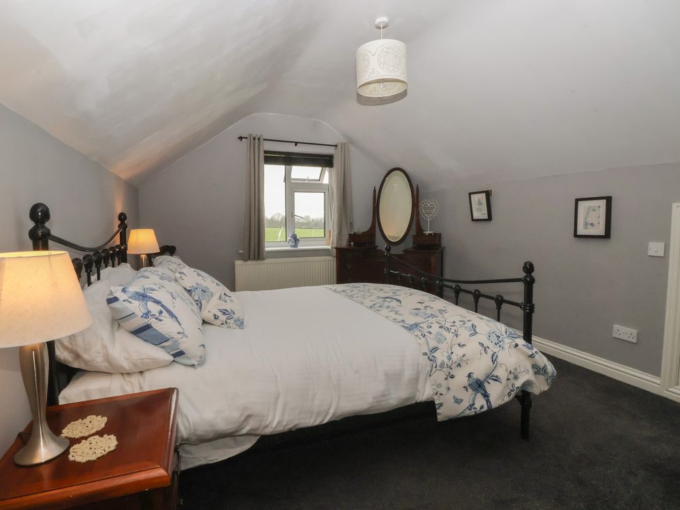 A bedroom with a bed and dressing table at Walnut Cottage in Helmsley