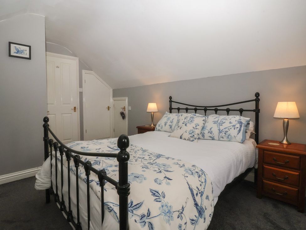 A bedroom with a bed and nightstand at Walnut Cottage in Helmsley
