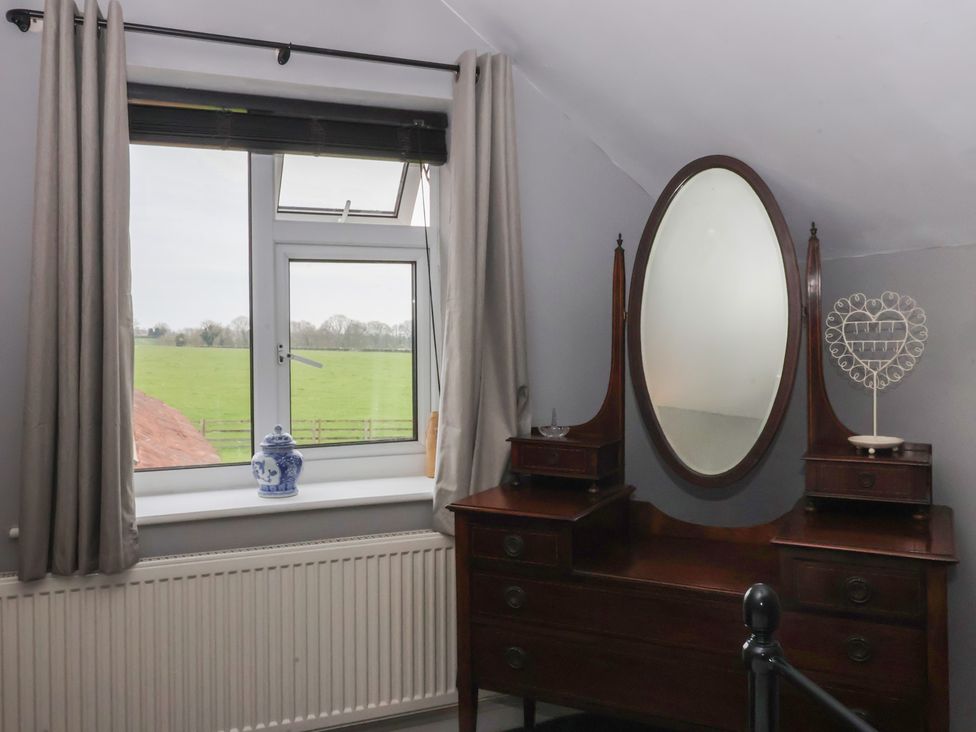 A bedroom with a vanity table and window at Walnut Cottage in Helmsley