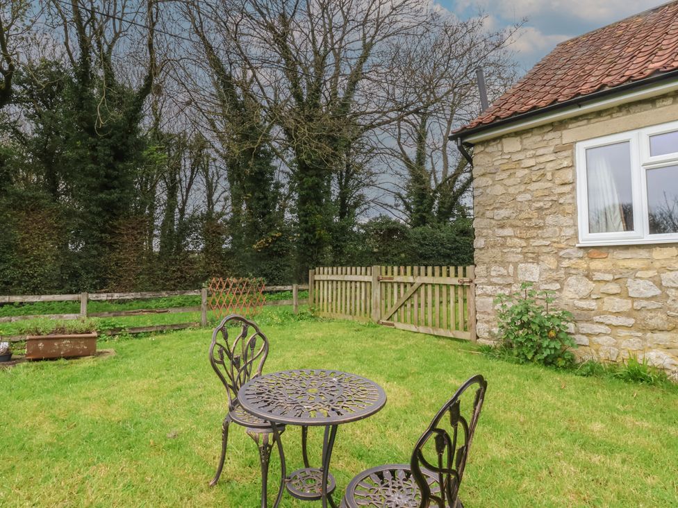 A garden with a table and chairs at Walnut Cottage in Helmsley