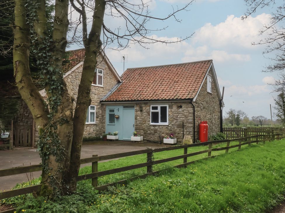 A house with a blue door and garden space at Walnut Cottage Helmsley