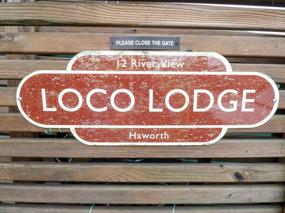 A sign displaying 12 River View Loco Lodge in Haworth