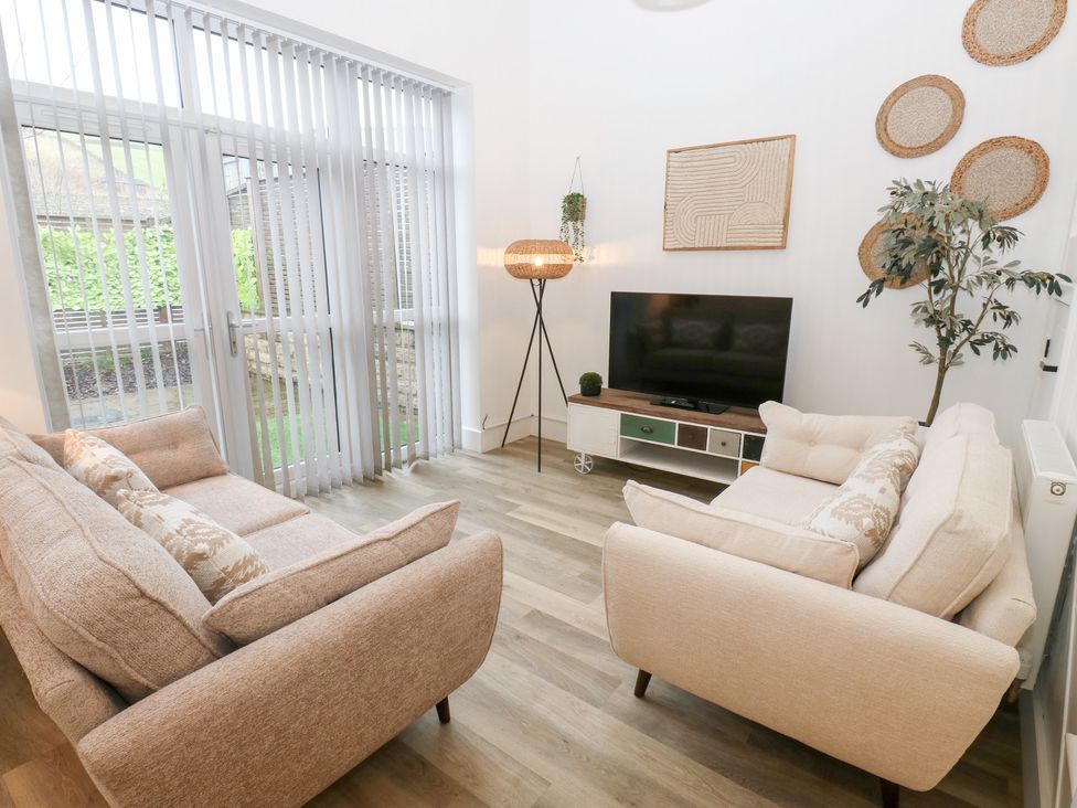 A living room with a sofa and television at 12 River View Keighley