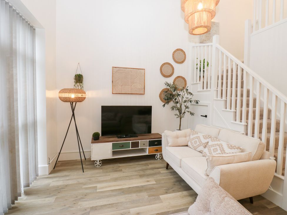 A living room with a sofa, television, and lamp at 12 River View in Keighley