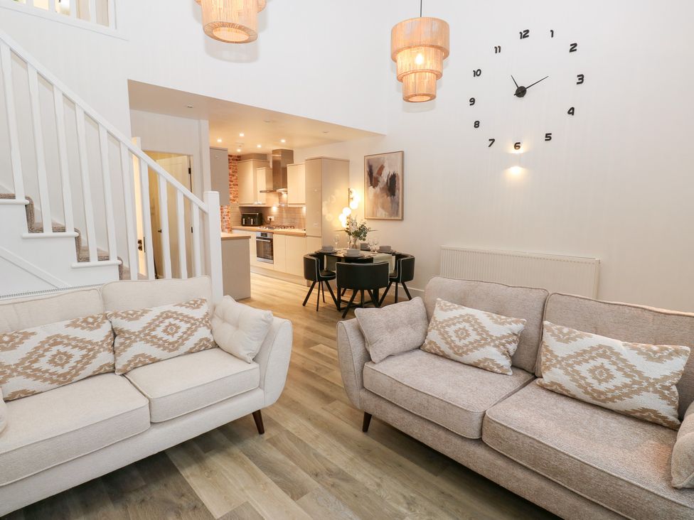 A living room with a sofa and a dining table at 12 River View in Keighley