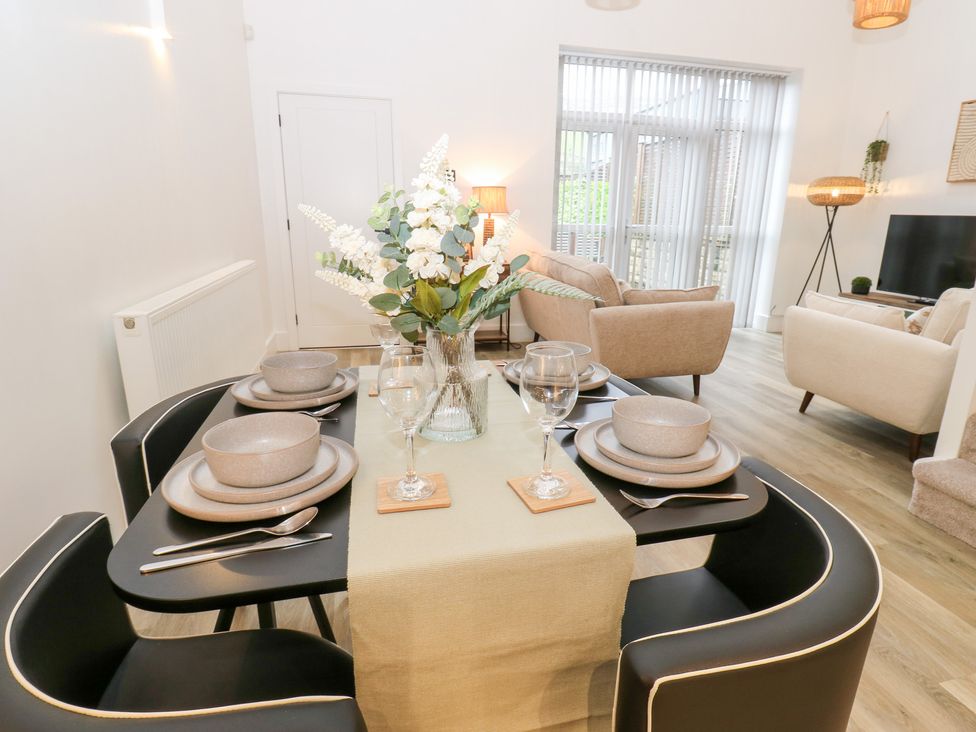 A dining room with a set table and flower arrangement at 12 River View Keighley