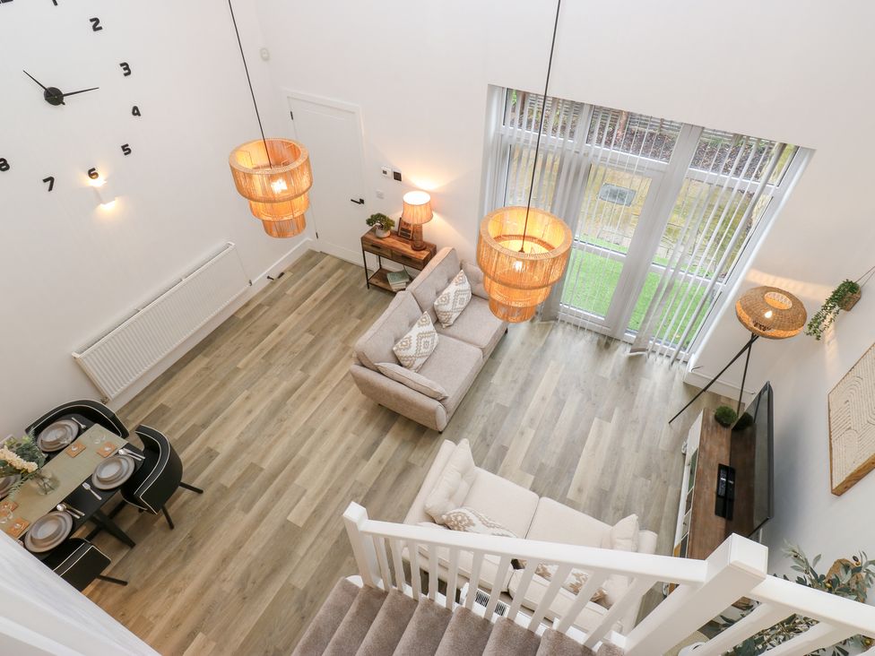 A living room with a sofa and dining area at 12 River View in Keighley
