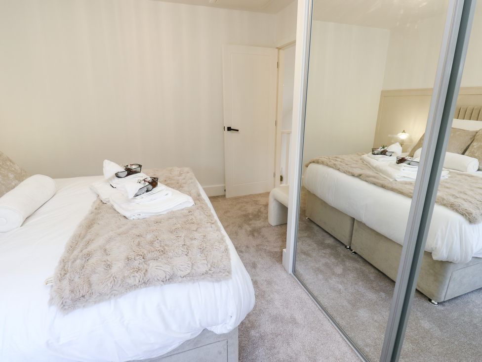 A bedroom with a bed and mirror at 12 River View in Keighley