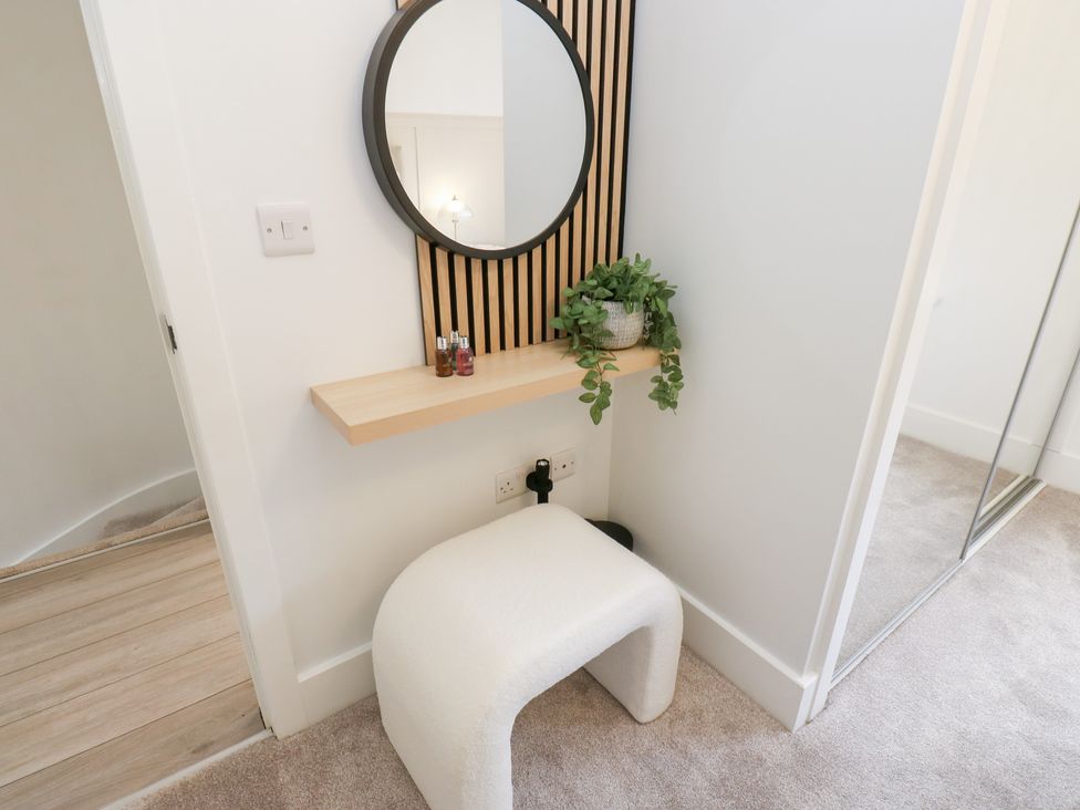 A hallway with a mirror and shelf at 12 River View Keighley