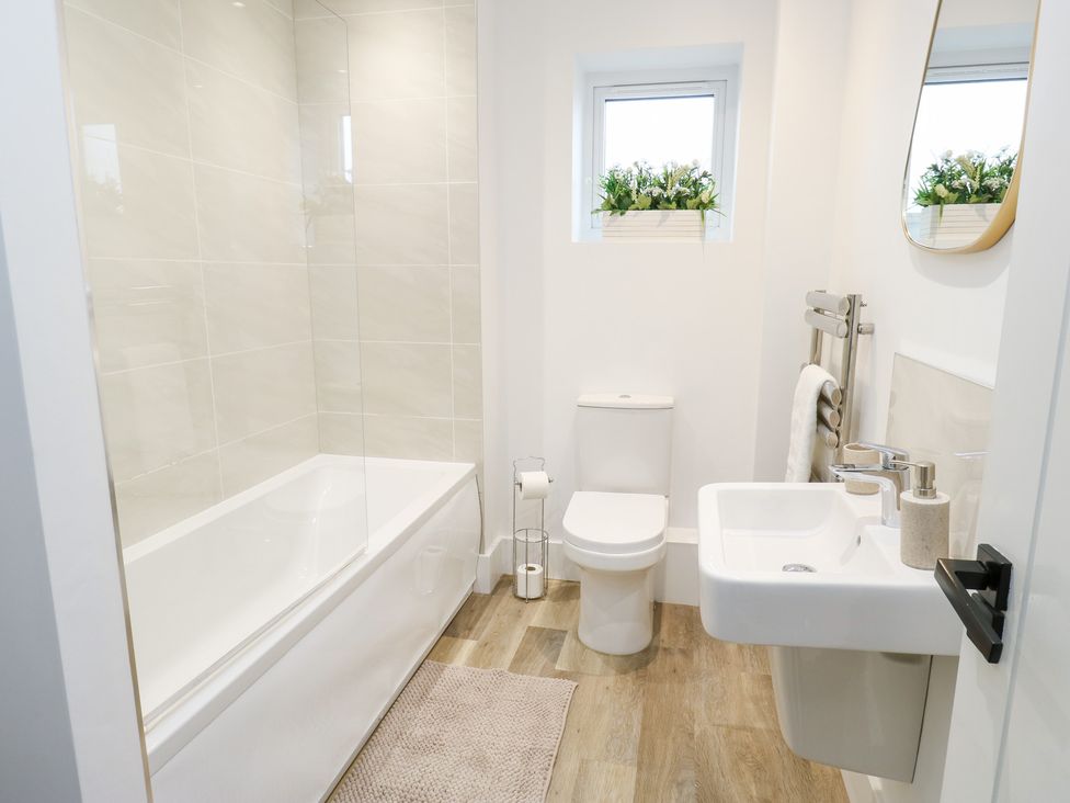 A bathroom with a bathtub and sink at 12 River View in Keighley