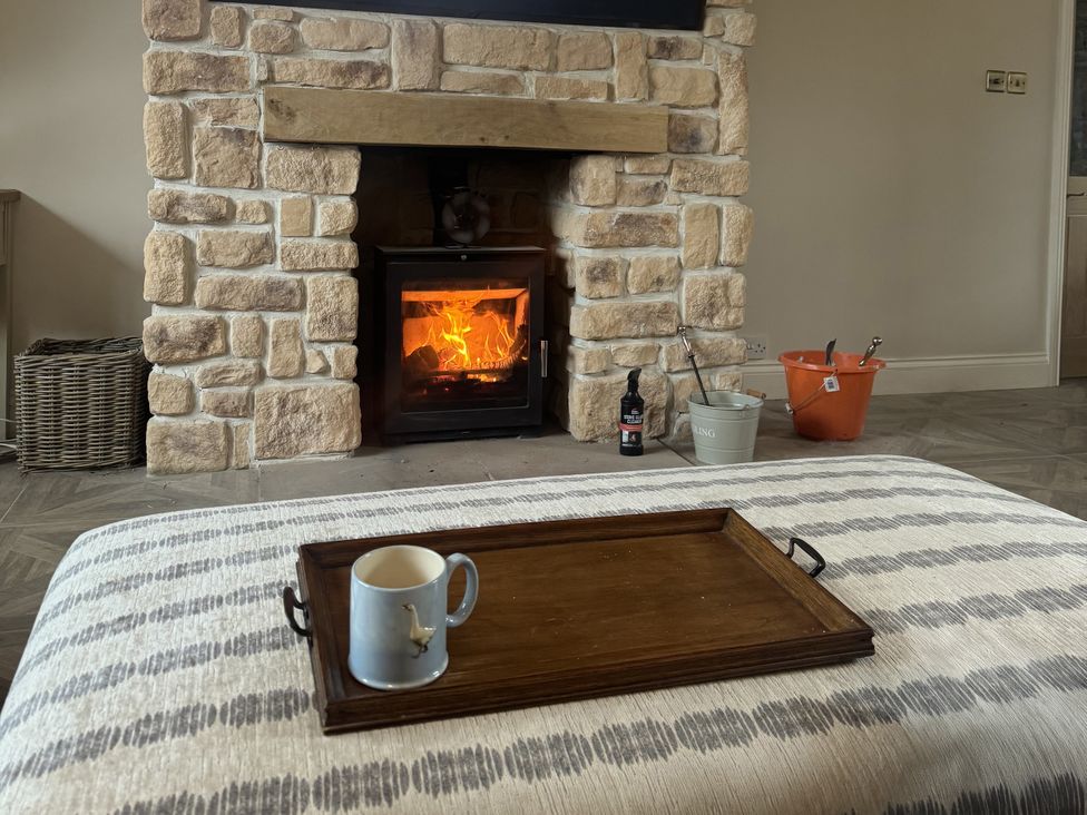 A living room with a fireplace and wooden tray at Yew Tree Cottage 