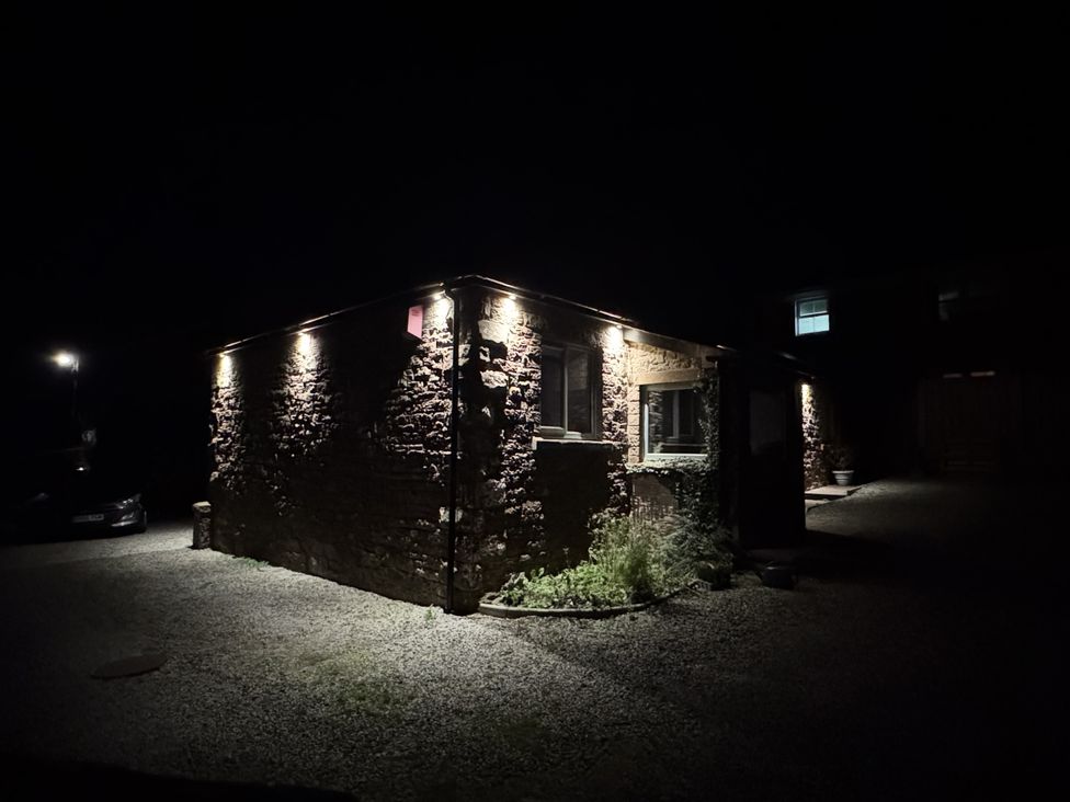 A building with lights at night at Yew Tree Cottage Mealsgate near Ireby