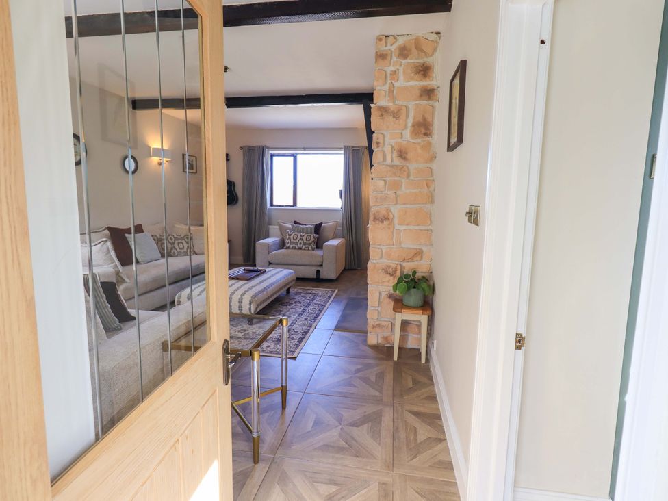 A living room with a sofa and chair at Yew Tree Cottage Mealsgate near Ireby